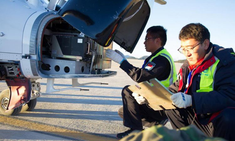 試飛前，機務在為AC312E配重。（岳書華 攝）