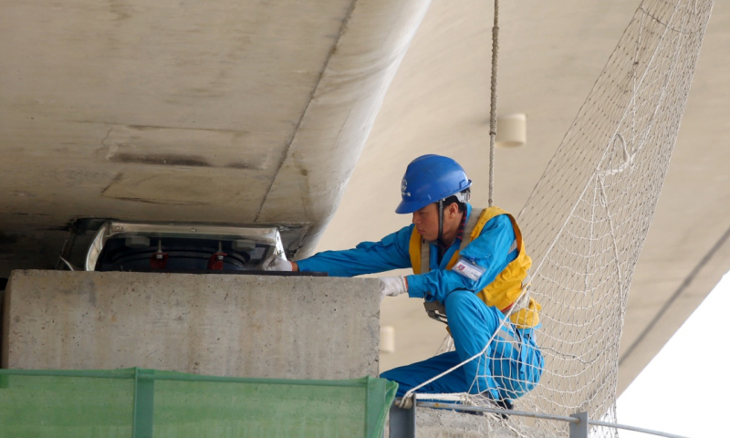 西成高鐵開通后，西安至成都列車運行時間將由目前的16小時縮短至3小時。這短短3小時的旅途凝聚了無數鐵路建設者的艱辛和汗水。圖為2016年5月30日，中鐵一局的施工人員在西成高鐵灃河特大橋上進行箱梁架設施工。（李一博 攝）