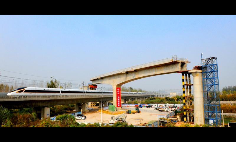 日前，中國鐵建所屬中鐵十二局施工的全國首個跨京滬高鐵轉體橋——徐鹽鐵路京滬上行線跨京滬高鐵特大橋完成轉體。為了這101米T梁跨線轉體，建設者們已為此奮斗了400多個日夜。圖為京滬高鐵復興號列車通過轉體橋。