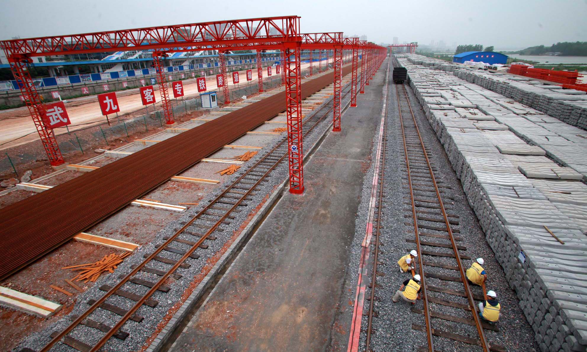 “與普通鐵路鋼軌只有25米長不同，武九客專全部采用長500米的鋼軌，鋼軌之間不再留縫隙，相當于把N條‘短面條’焊成一條無縫隙‘長面條’。”中國鐵建十八局集團武九鋪軌項目部經理韓少華說：“這樣不僅減少了與車輛的摩擦力，使車輛運行速度更快，而且使旅客在列車高速運行時更加安全舒適。”圖為十八局二公司武九客專陽新鋪軌基地（伍振 攝）。