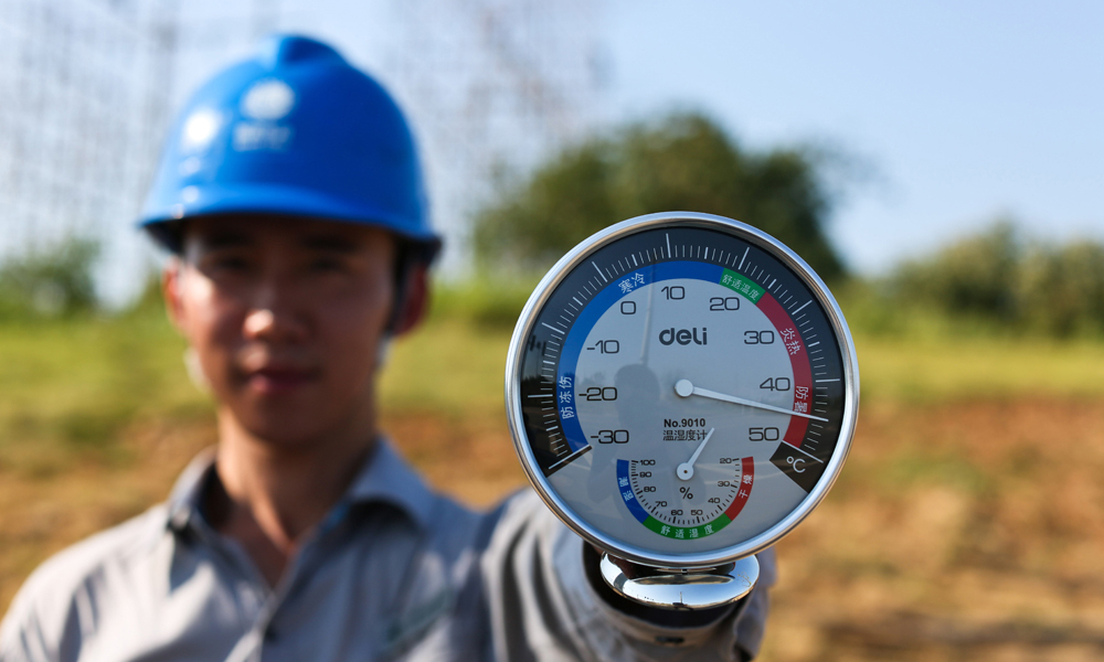 7月21日，安徽銅陵市義安區供電公司一位變電檢修工日轄區內35千伏、10千伏線路進行紅外測溫工作。圖為當天他手舉溫度計，表上顯示此時戶外溫度高達45攝氏度。 （陳晨 攝）