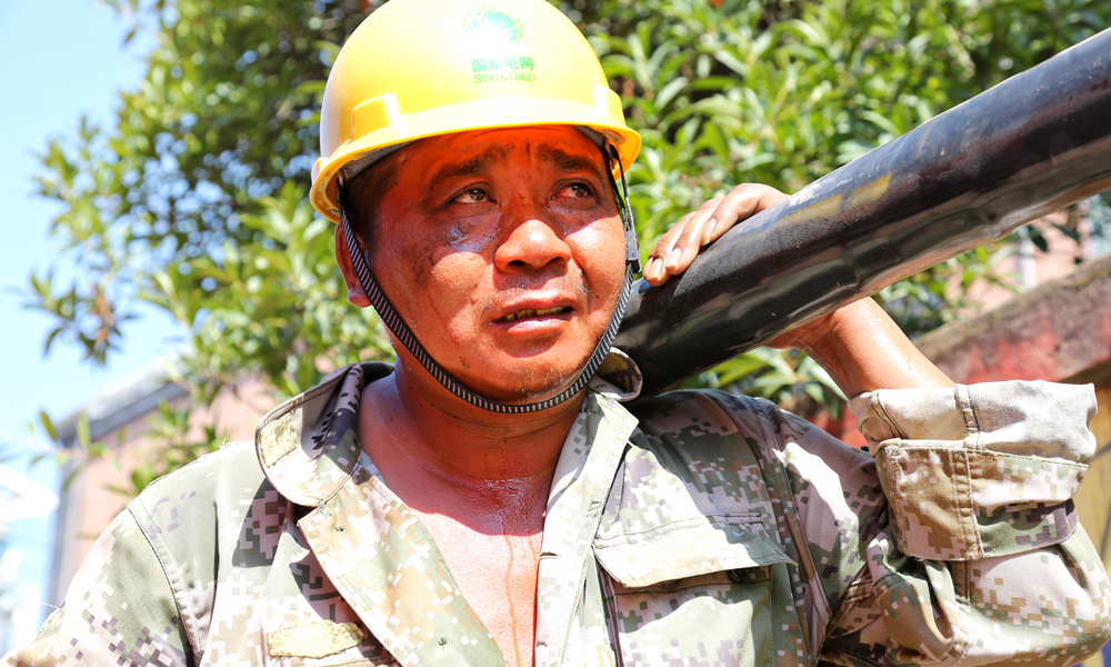 7月22日，江西上饒供電公司搶修人員冒42攝氏度高溫搶修受損線路。當日，上饒縣城110千伏旭日變電站因居民焚燒席夢思床造成燒損，18條10千伏線路被迫停電。（蔣瑛 攝）