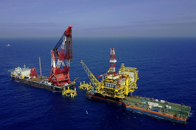 “海洋石油228”承載著1.3萬噸的上部組塊即將進入導管架槽口進行浮托安裝作業。（來源：中國海洋石油總公司）