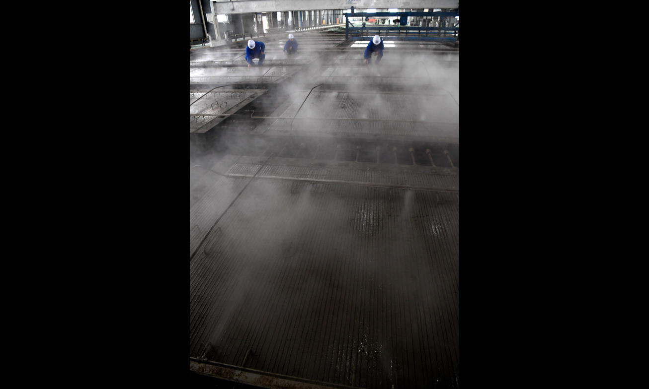 據悉，CRTSⅢ型先張法預應力混凝土軌道板是我國自主研發、具有完全自主知識產權、實現技術創新的一項重大科技成果，是我國高速鐵路無砟軌道技術實現國產化的重要標志。圖為中鐵十一局橋梁公司江西豐城制板場職工在運用自主研發的智能霧化養護系統對CRTSⅢ型先張法軌道板進行養護。（新華社記者 宋振平 攝）