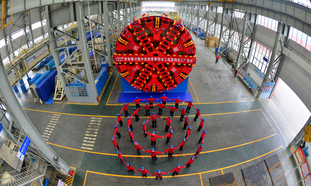 該設備開挖直徑9.05米，總長約132米，整機重量約1500噸，裝機功率3500千瓦，由中國鐵建重工集團、中國鐵建大橋局集團、寧夏華電靈武公司聯合研制，擁有完全自主知識產權。圖為“初心號”與生產班組合影。（黃星霖 攝）