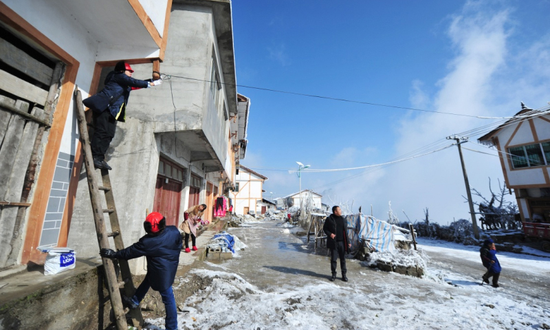 2018年1月9日，務川供電局工作人員文應龍（左一）與同事李進在貴州務川仡佬族苗族自治縣石朝鄉高峰村幫助當地村民接搭線。（新華社記者 陶亮 攝）