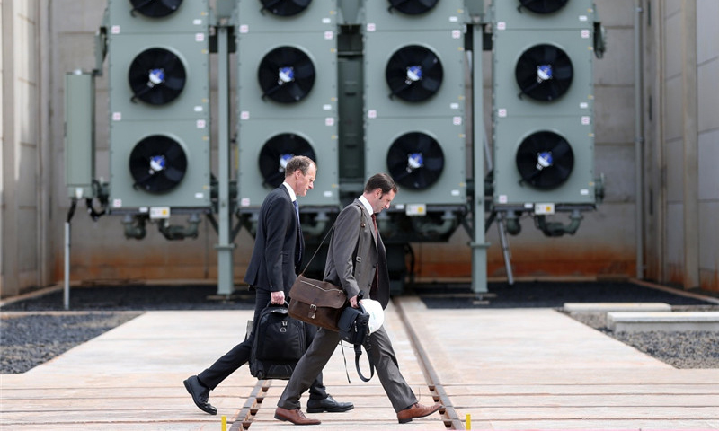 12月21日，在巴西米納斯吉拉斯州伊比拉西市，兩名當地參會者前往儀式現場。（新華社記者 李明 攝）