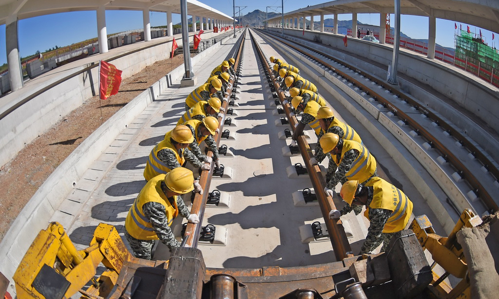 京沈高鐵起自北京星火站，經河北省承德市、遼寧省朝陽市、阜新市接入沈陽站，線路全長698公里，設計時速350公里。圖為2017年9月28日，中鐵十九局工程人員在京沈高鐵凌源南站進行鋪軌作業。（新華社記者&nbsp;楊青&nbsp;攝）