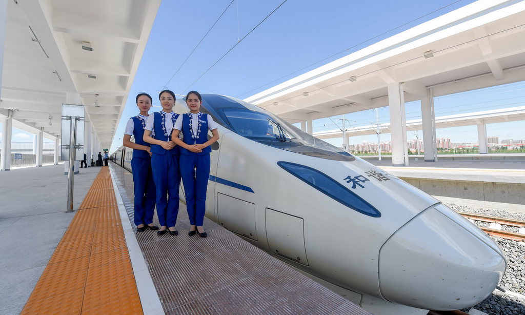 2017年8月3日，內蒙古首列高鐵D6980次列車伴隨著嘹亮的汽笛聲，駛出呼和浩特東火車站，以250公里的時速駛向烏蘭察布站，內蒙古自此正式邁進高鐵時代。圖為乘務組人員在烏蘭察布站與動車組合影。（新華社記者 連振 攝）
