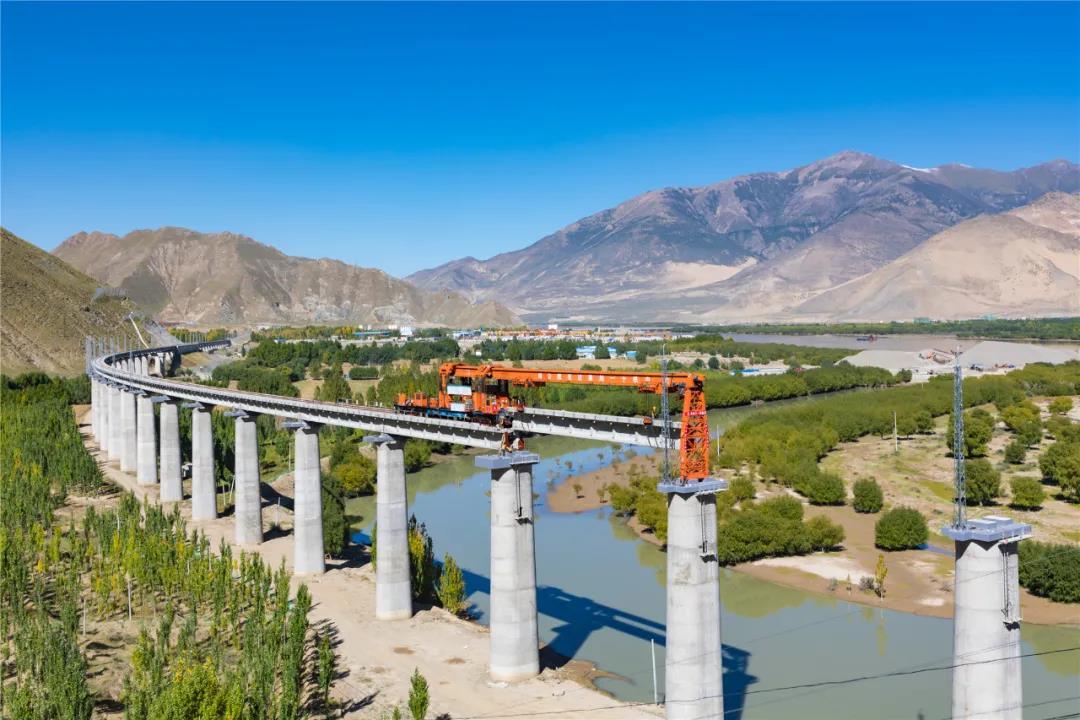 拉林鐵路90%以上路段位于3000米以上的高海拔地區，既有高原高寒缺氧、生態脆弱的嚴酷自然環境，更面臨頻發多變的風積沙、冰磧層、強巖爆、高地溫和軟巖大變形等復雜地質環境。其中，橋梁120座，隧道47座，橋隧比高達74.66%。全線還16次穿越雅魯藏布江，工程施工極其困難。圖為拉林鐵路程巴特大橋T梁架設。