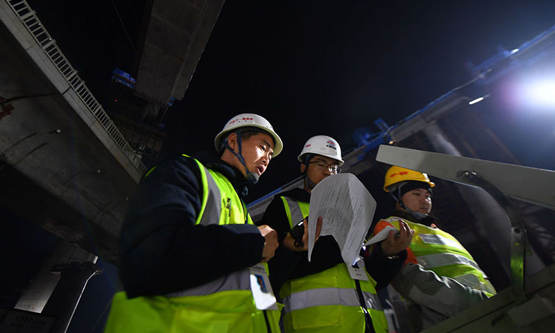 常益長鐵路全長157公里，設計時速350公里，是國家“八縱八橫”高速鐵路網的重要組成部分。圖為12月25日凌晨，中鐵十一局技術人員對照操作臺記錄轉體梁轉動角度和弧長。（新華社記者 趙眾志 攝）