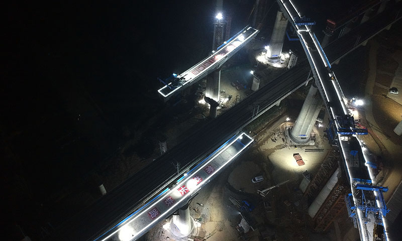 圖為12月24日晚，即將實施轉體的常益長鐵路“動走右線2號特大橋連續梁”（左側橋）及已經完成轉體的“動走左線特大橋連續梁”（右側橋）。（新華社記者 趙眾志 攝）