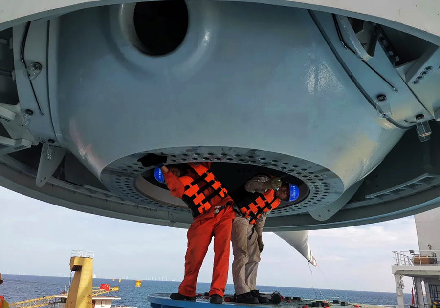 該項目計劃2021年10月31日前完成全部60臺風機安裝施工并全容量并網發電，項目建成后，預計年上網電量約7.7億千瓦時，類比同級煤電，每年可節約標煤23.5萬噸，減少污染物排放2600噸。圖為輪轂底座法蘭盤清理。