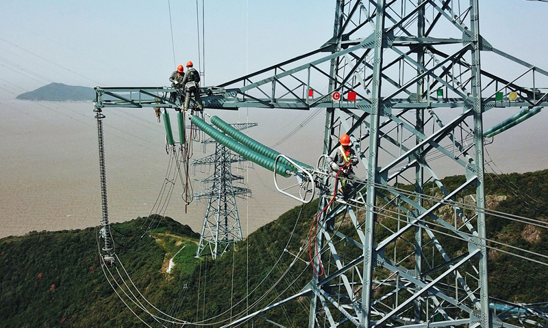 近期，浙江省國網舟山供電公司組織人員對浙江舟山500千伏聯網輸電線路洛遠線進行綜合檢修，這也是該線路自2019年通電投運以來的首次檢修。圖為10月24日，檢修人員在跨海輸電高塔上進行檢修工作。（新華社記者 徐昱 攝）