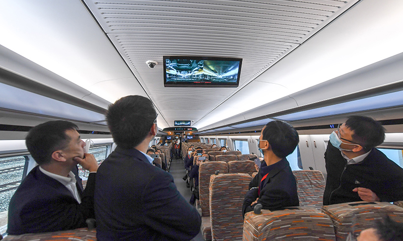 10月21日，在中車長春軌道客車股份有限公司，試乘人員通過車內屏幕觀看時速400公里跨國互聯互通高速動車組變軌運行情況。（新華社記者 張楠 攝）