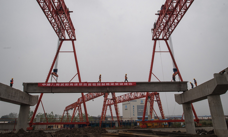 10月18日，由中建三局承建的武（武漢）陽（陽新）高速鄂州段二標首榀預制箱梁架設成功，全線施工加速推進。武陽高速起于武漢東湖高新區鳳凰山互通，止于陽新縣木港鎮。這條高速公路是武漢市東南通道的重要組成部分。圖為當日，來自中建三局的建設者在武陽高速鄂州段建設現場施工。（新華社記者 肖藝九 攝）