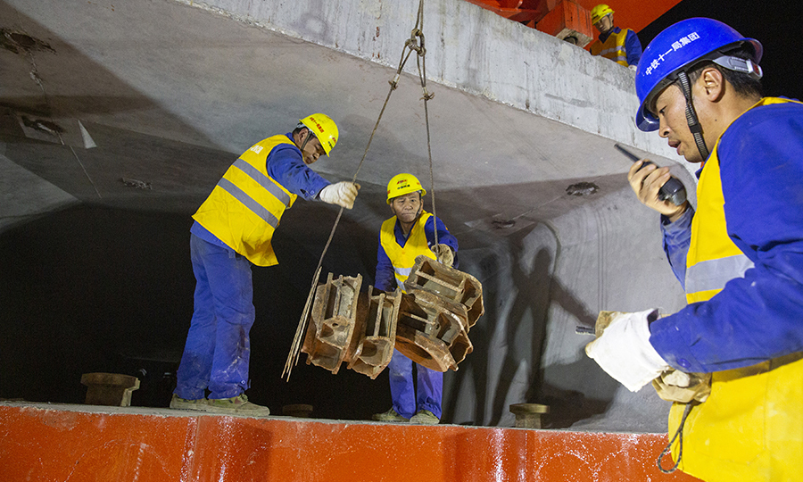 圖為10月11日凌晨，中鐵十一局職工準備安裝箱梁吊具。（彭特 攝）