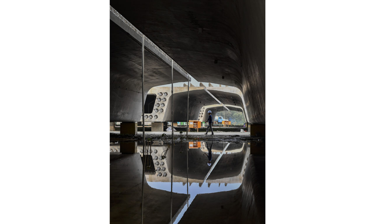 圖為10月13日，工人從中鐵十一局常益長鐵路望城西制梁場已經完成制作的混凝土箱梁邊走過。新華社發（王荃荃 攝）