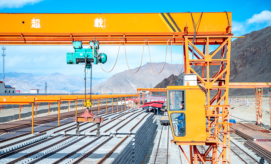 圖為女職工袁芳在高空中，用龍門吊將臺位上的軌排做調整。（丁慶濱 攝）