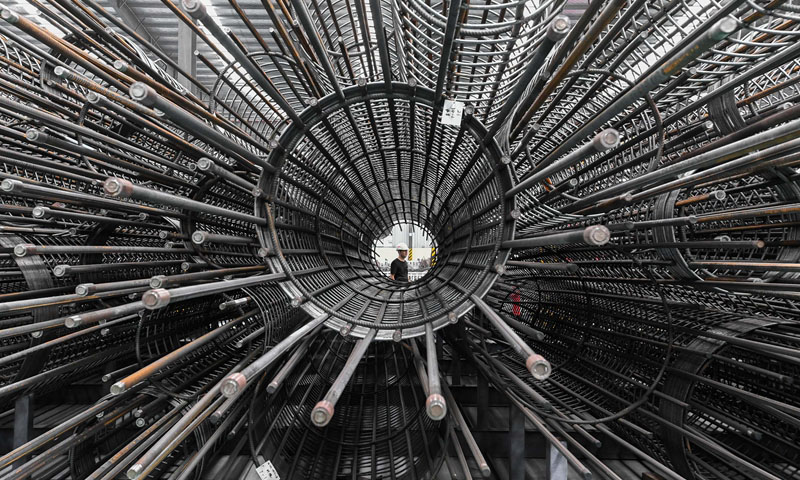 圖為9月20日，工人從中國鐵建華南建設有限公司番禺鋼材加工中心鋼筋籠成品倉庫經過。（新華社記者 劉大偉 攝）