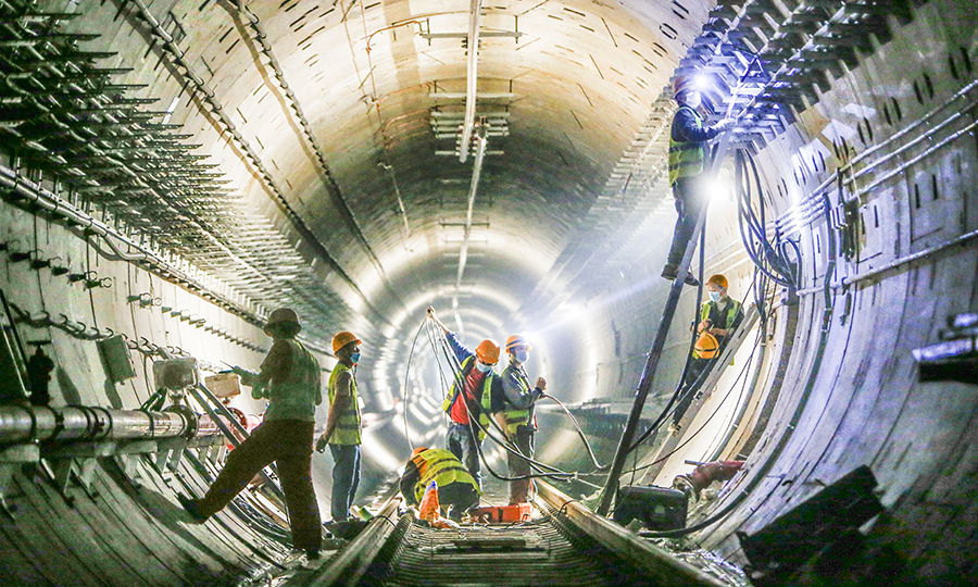 西安地鐵5號線西起阿房宮南站，東至西安東站，全長25.36公里，共設21座車站，由中鐵十四局電氣化公司承建6站6區間的機電安裝、砌筑裝修工程。圖為在地鐵區間內施工的人員。（范成濤 攝）