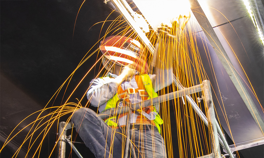 裝配式施工不但避免了傳統施工造成的空間利用不足、管線錯綜復雜、搶工返工的現象，并大大節省了材料、減少了施工成本。圖為技術人員正在進行設備焊接。（范成濤 攝）