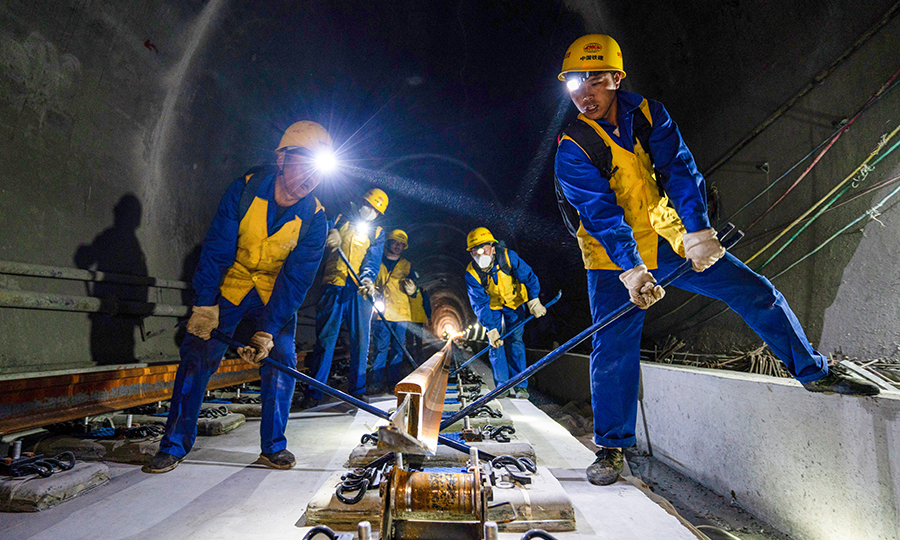 拉林鐵路全長435.48公里，全線區間無縫對接，設計時速為每小時160公里。其中橋隧總長300.975公里，橋隧比高達74.66%，被譽為高原上的地鐵。今年4月7日，拉林鐵路全線隧道貫通；7月4日，最后一座跨雅魯藏布江特大橋T梁順利架設完成，為后續鋪軌工作贏得了時間，提供了作業面。圖為施工人員正在進行長鋼軌推送作業。