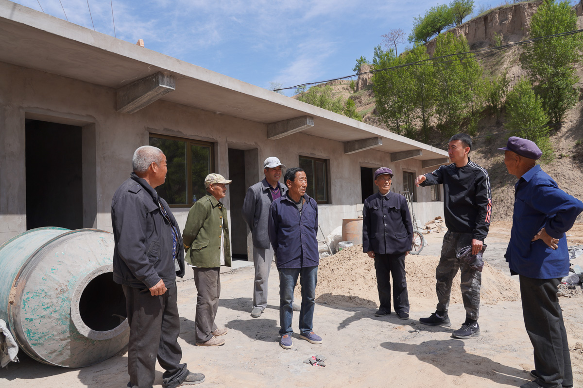 圖為高飛和村干部們商量扶貧項目如何進展。