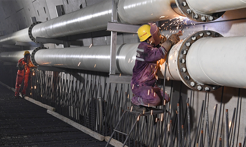 盾構機未加采石箱前，石塊在管道中橫沖直撞，給泥漿管道以破壞性打擊，10毫米厚的鋼板管道被磨穿，出漿管到處漏漿。盾構工作人員急中生智，將10米長的出漿管道旋轉180度使用，或使用加大壁厚的成型管道。其次，進漿管路和出漿管路互換，在管道接口加上一個彎頭，換道“行車”，進泥水廠前再加一處彎頭各歸各路。同時，立即找準磨損規律，在容易磨壞管道的位置，打“補丁”精準焊接鋼板。圖為電焊工對隧道內磨穿的泥漿管路進行補焊。