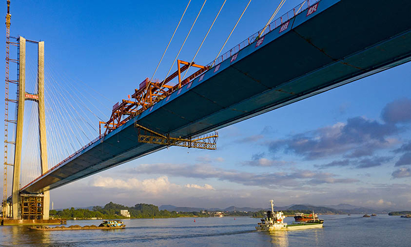 大橋橋址環境復雜，傳統孔跨布置方案無法滿足通航及防洪要求。設計團隊創新性采用非對稱布置混合梁斜拉橋，為國內同類型的橋梁建設提供了寶貴的經驗。針對貨運鐵路荷載重、速度低的特點，設計寬跨比近1/30，橋面布置更為緊湊，進一步提升了貨運鐵路斜拉橋的經濟性。圖為合龍現場。（金偉 攝）