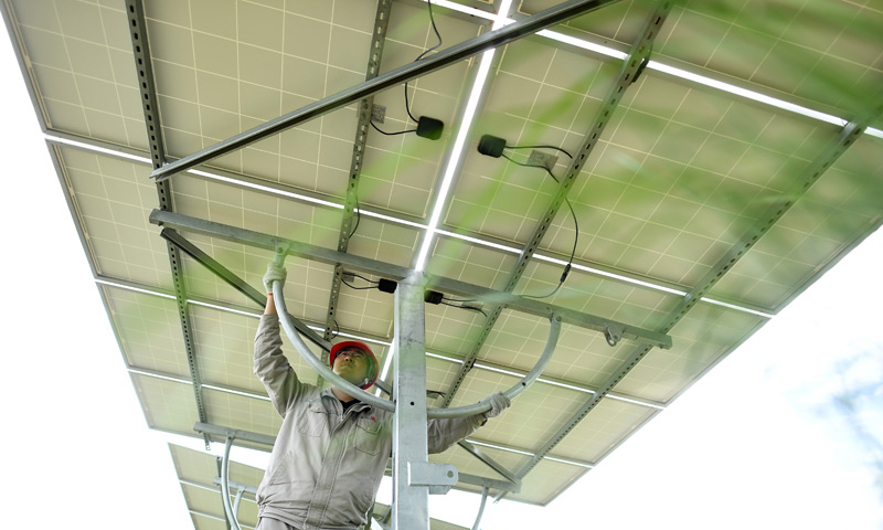 圖為7月8日，在青海省海南藏族自治州共和縣，大唐青海公司新能源分公司工作人員許源在光伏電站內調整光伏電池板角度。（新華社記者 張宏祥 攝）