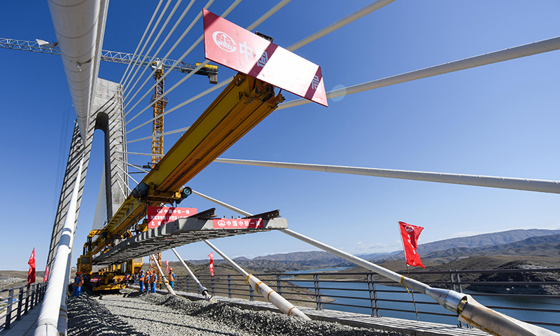 圖為7月2日，中鐵一局的施工人員在阿富準鐵路阿勒泰至富蘊段進行鋪軌作業。（新華社記者 丁磊 攝）