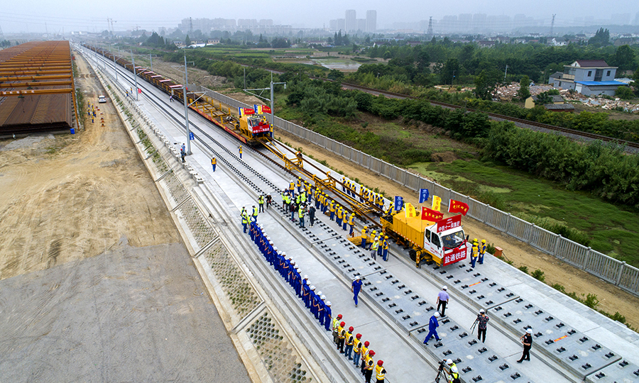 鹽通高鐵位于鹽城、南通境內，是國家“八縱八橫”高鐵網中沿海通道的重要組成部分，全線設鹽城、大豐、東臺、海安、如皋南和南通西6座車站，正線全長156.6公里，設計時速350公里。中鐵十一局承擔著全線軌道鋪設和121組道岔的鋪設任務。圖為鹽通高鐵全線首鋪現場。（劉連強 攝）