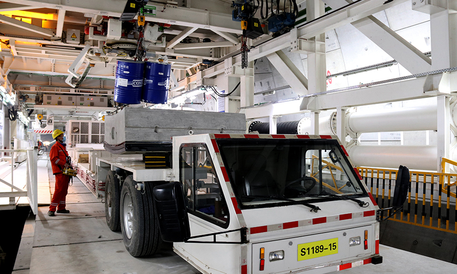 日前，中國鐵建所屬中鐵十四局承建的南京和燕路過江隧道全面復工。該項目一手抓防疫，一手抓施工，200余名建設者日夜奮戰，盾構機正以平均每天10米的速度向前掘進。圖為盾構隧道內，吊機操作手正在吊裝盾尾油脂桶。