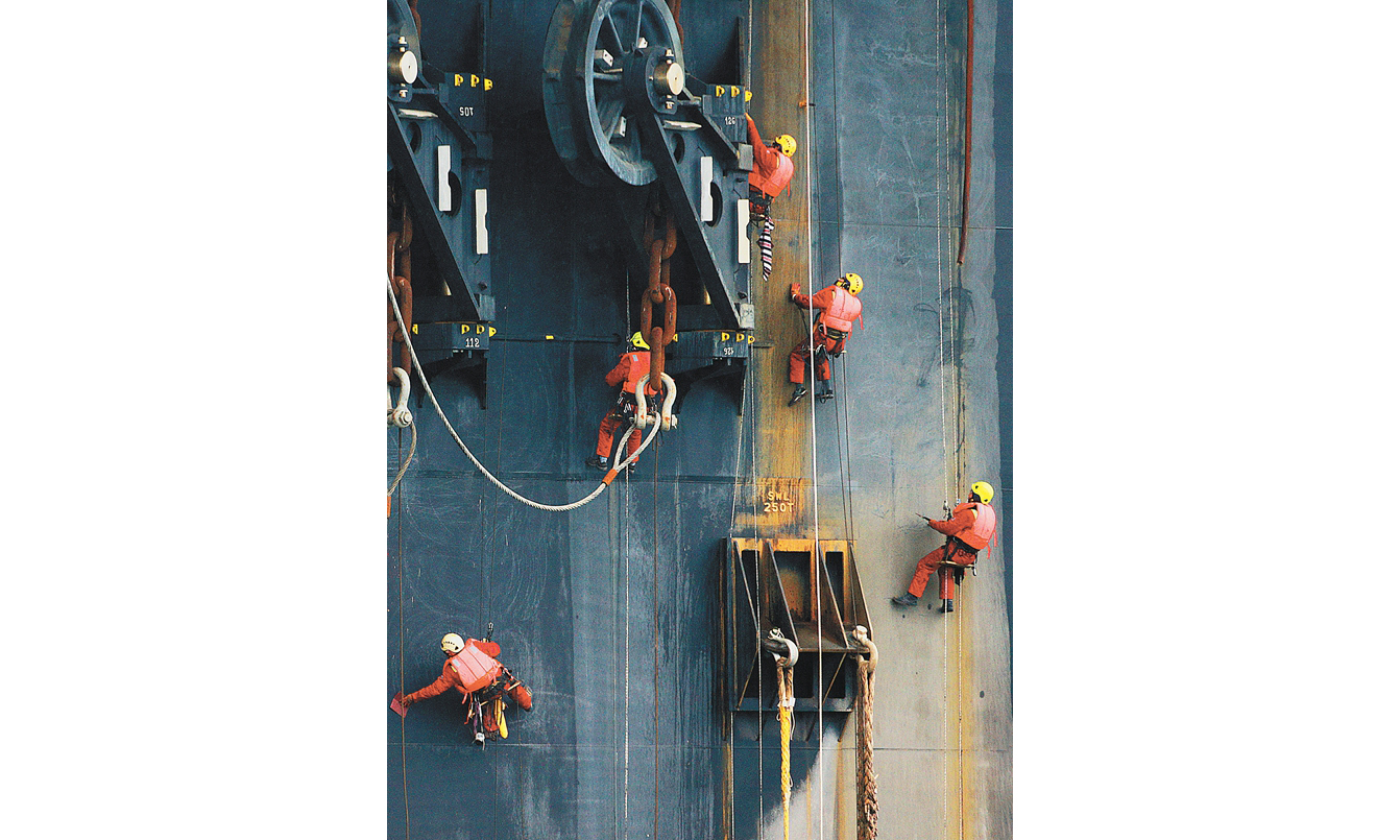 圖為P70交付前夕，施工人員附在船體高空，對船體進行油漆粉刷。