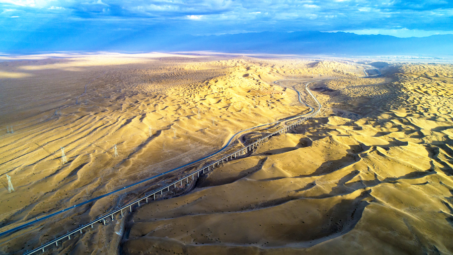敦格鐵路北起甘肅省敦煌市敦煌站，南至青海省格爾木市格爾木站，全長616.79公里，其中新建線路509.02公里，設計時速120公里，是國鐵I級電氣化單線鐵路。圖為沙山溝特大橋高空俯拍。（金偉 攝）