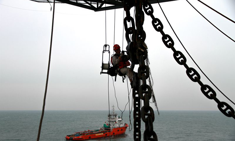 圖為現場作業人員懸掛高空，對龍須鏈進行探傷檢測。