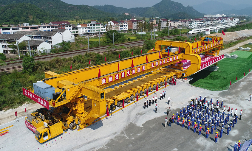 9月29日上午10時16分，在杭（州）紹（興）臺（州）高鐵施工現場，隨著架橋機將首榀長32.6米、重790.3噸的箱梁緩緩架設在浙江臨海瑯坑特大橋橋墩上，標志著我國首條民營資本控股的高速鐵路——杭紹臺高鐵架梁施工全面展開。圖為首榀箱梁架設現場。（李萬里 攝）