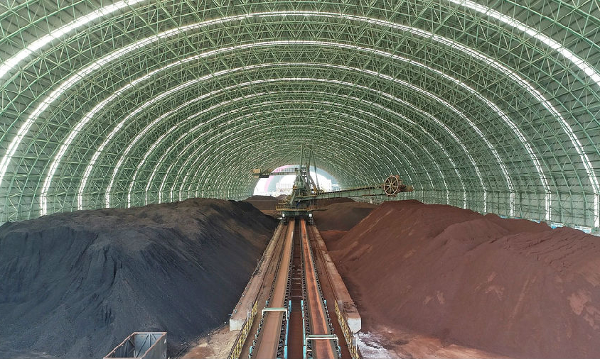 聯合鋼鐵項目展現了一座技術先進、節能環保的現代化鋼鐵企業范本。項目完全按照全流程生產工藝，采用包括信息自動化技術、節能減排技術、循環回收技術等一批先進的工藝，環保投資占比高達16.15%，資源回收利用率高。圖為環保型原料場，可降低80%以上物料損耗，減少90%以上顆粒物揚塵。