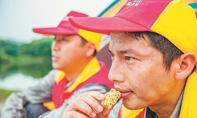 安徽省池州青陽山區特高壓密集通道的運檢工作，由國網安徽電力有限公司送變電工程公司運檢站36名工作人員承擔。圖為巡檢過程中，工作人員吃干泡面充饑。