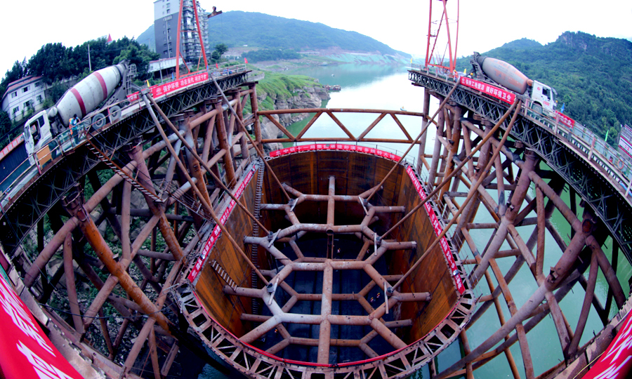 為克服施工難題，中鐵十一局鄭萬項目組采用高樁棧橋搭建鉆孔平臺方法進行水中樁基施工，樁基施工工藝采用反循環清孔撈渣鉆孔灌注施工。該項目組成立技術研發中心，除了對工程難點進行技術攻關，還承擔了《陡坡河床及水位大幅度升降條件下橋梁施工關鍵技術研究》課題的攻關任務。圖為混凝土澆筑施工。（劉興敏 攝）