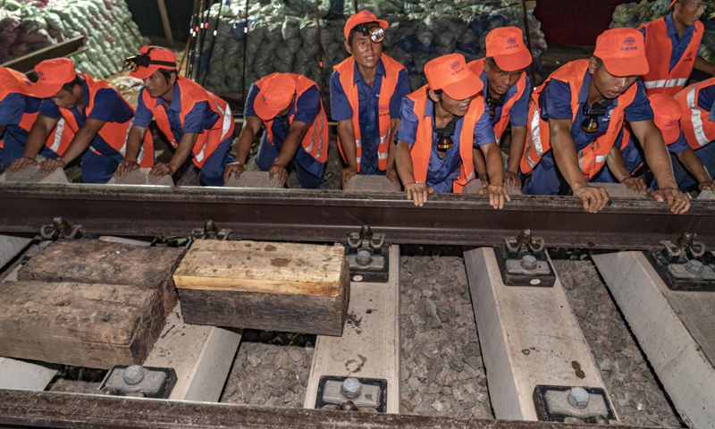 昌贛高鐵全長415.734公里，北起江西南昌，南至贛州，設計時速350公里。這條高鐵建成通車后，井岡山革命老區、贛南等原中央蘇區將正式邁入高鐵時代。圖為7月19日凌晨，中鐵十一局三公司職工在推入道岔。（新華社記者 杜華舉 攝）