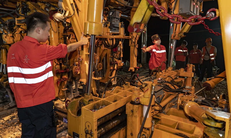 圖為7月19日凌晨，中鐵十一局三公司技術人員在指揮大型搗固車，對新鋪設的道岔進行大機養護。（新華社記者 杜華舉 攝）