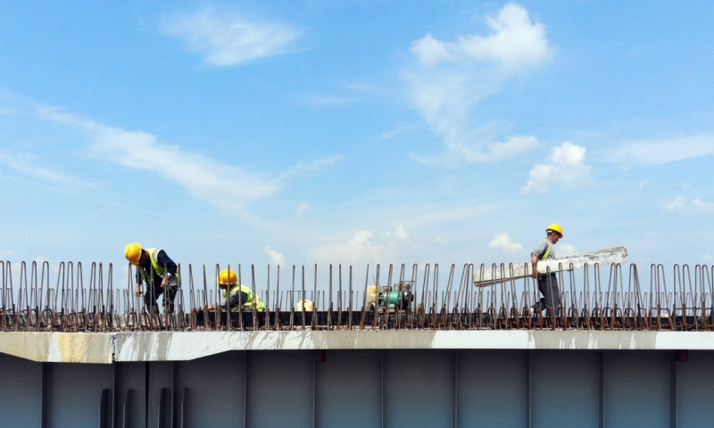 長春連日來持續高溫。為確保京哈高速長春至拉林河段改擴建工程按期完工，中國交通建設股份有限公司的千余名筑路工人冒著高溫，奮戰在熱浪滾滾的一線工地，加緊進行路基、路面、橋涵和環保綠化等工程施工。圖為7月9日，工人在京哈高速長春至拉林河段改擴建工程現場施工。（新華社記者 林宏 攝）