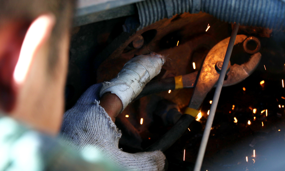 現場施工多半為臨水臨坡作業，在施工過程中，右岸滑坡體隨時有垮塌風險，滾石等經常滑落，加之需夜間施工，危險系數較高。圖為6月24日，修理工人左手受傷，仍堅守工作崗位。（李明 攝）