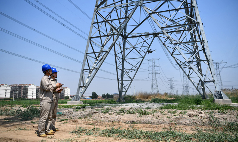 6月24日，天津氣象部門發布高溫橙色預警信號，部分地區最高氣溫超過37℃。國家電網天津檢修公司特高壓輸電運檢室無人機巡檢班的電力工人依照“迎峰度夏特巡”要求，在魯固、錫泰、廊河三條特高壓輸電線路并行處開展無人機巡檢工作，確保輸電安全。圖為6月24日，電力工人操作無人機準備開始巡檢工作。（新華社記者 李然 攝）