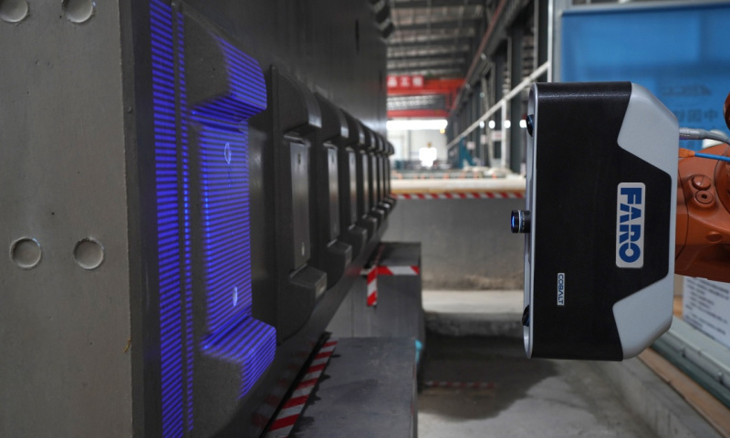 近日，經智能機器人檢測合格的第15000塊高鐵CRTSⅢ型軌道板在京沈高鐵京冀段北京密云巨各莊制板廠下線，標志著我國高鐵軌道板自動檢測技術達到國際先進水平。圖為6月17日，高速鐵路CRTSⅢ型軌道板自動化檢測系統對高鐵軌道板進行檢測。（新華社記者 鞠煥宗 攝）