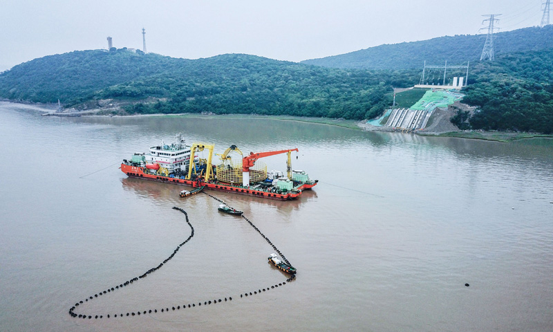 圖為6月2日，最后一段海底電纜從海纜施工船上緩緩拖向舟山大鵬山島的終端站。（新華社記者 徐昱 攝）