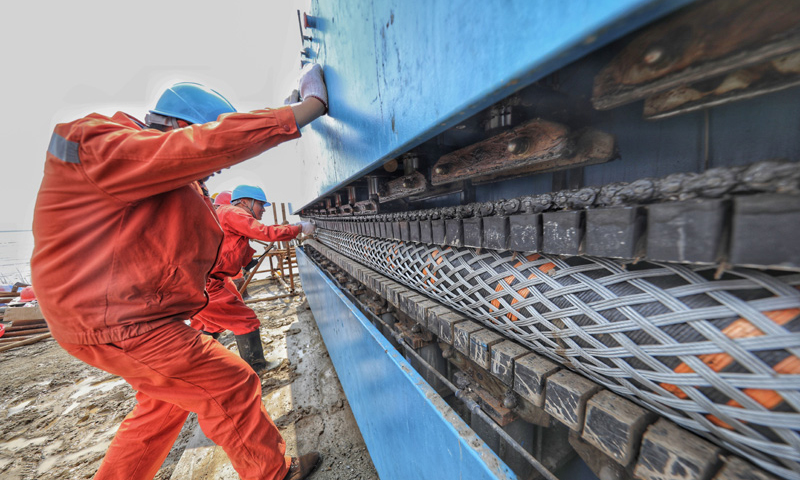 圖為6月2日，工作人員在查看已經順利登陸的海底電纜。（新華社記者 徐昱 攝）