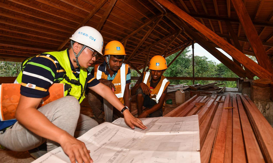 項目經理胥超對著圖紙給當地工人講解施工要求。